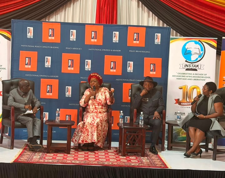 A panel participant speaks into a microphone on the INSTAK@10 stage.