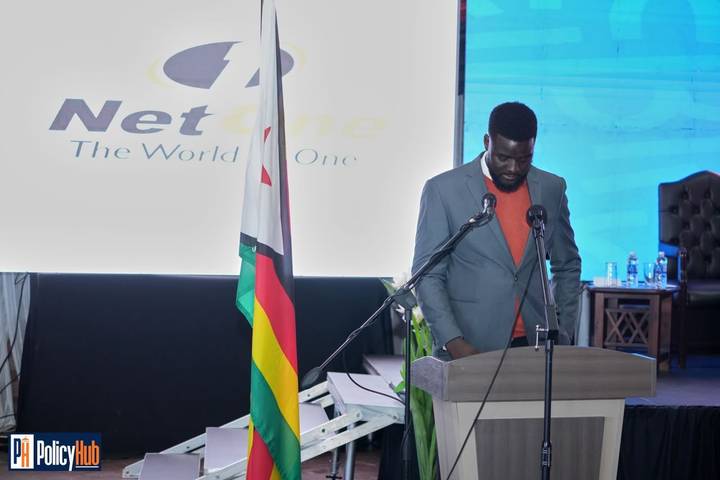 Speaker at podium beside the Zimbabwe flag